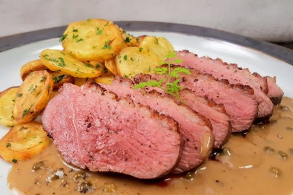 viande rouge avec de la sauce au poivre vert